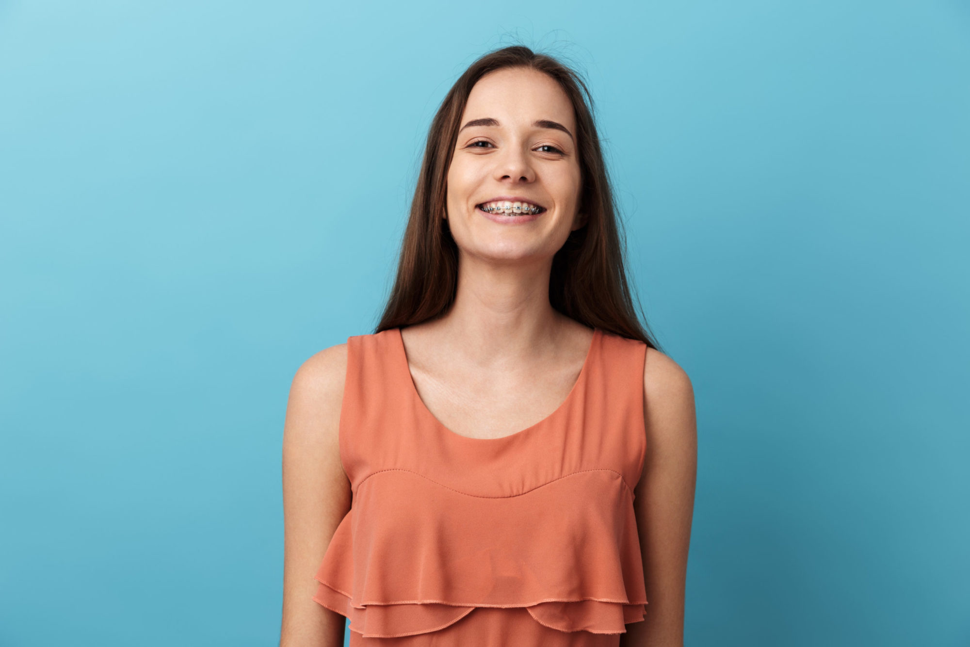 Smiling female patient wearing metal braces from an orthodontist in Omaha, NE